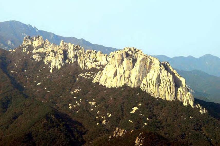 숲으로 덮인 산 능선 위로 밝은 화강암 암봉이 길게 이어진 설악산 울산바위