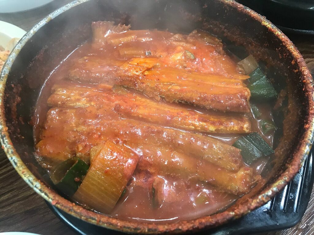 냄비에 갈치 토막과 무, 대파를 넣고 붉은 양념에 졸인 갈치조림