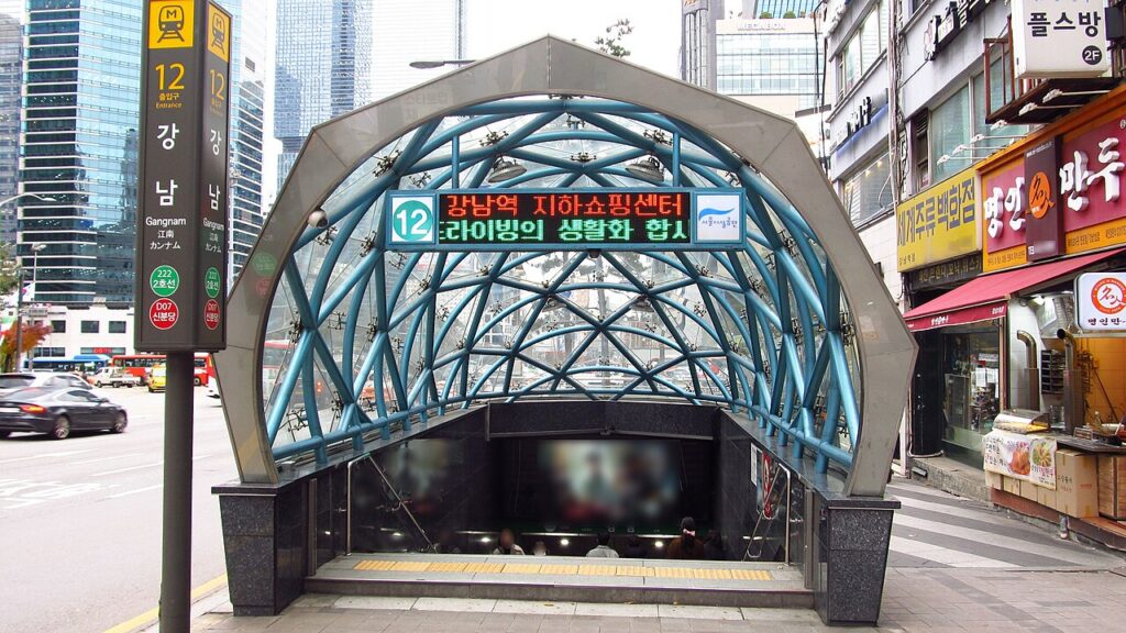 강남역 12번 출구의 파란 철골 아치와 지하쇼핑센터 안내판, 지하로 내려가는 계단