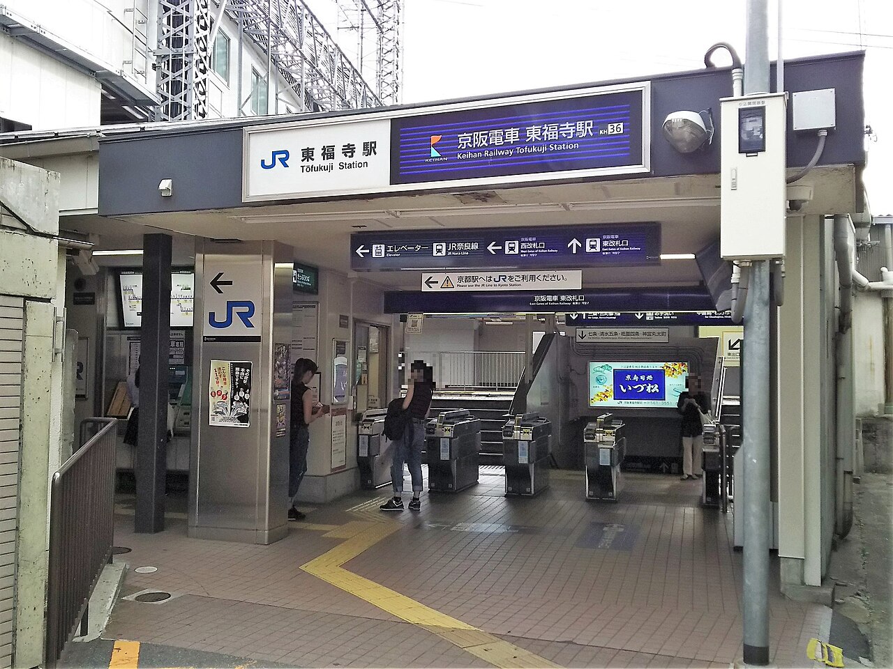 JR과 게이한 도후쿠지역 간판 아래 노선 방향 안내와 개찰구가 보이는 역 입구